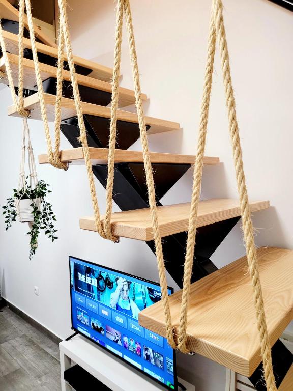 a room with a tv and rope shelves at Casinha da Esquina - Refúgio Alentejano a 700m da Praia in Amieira