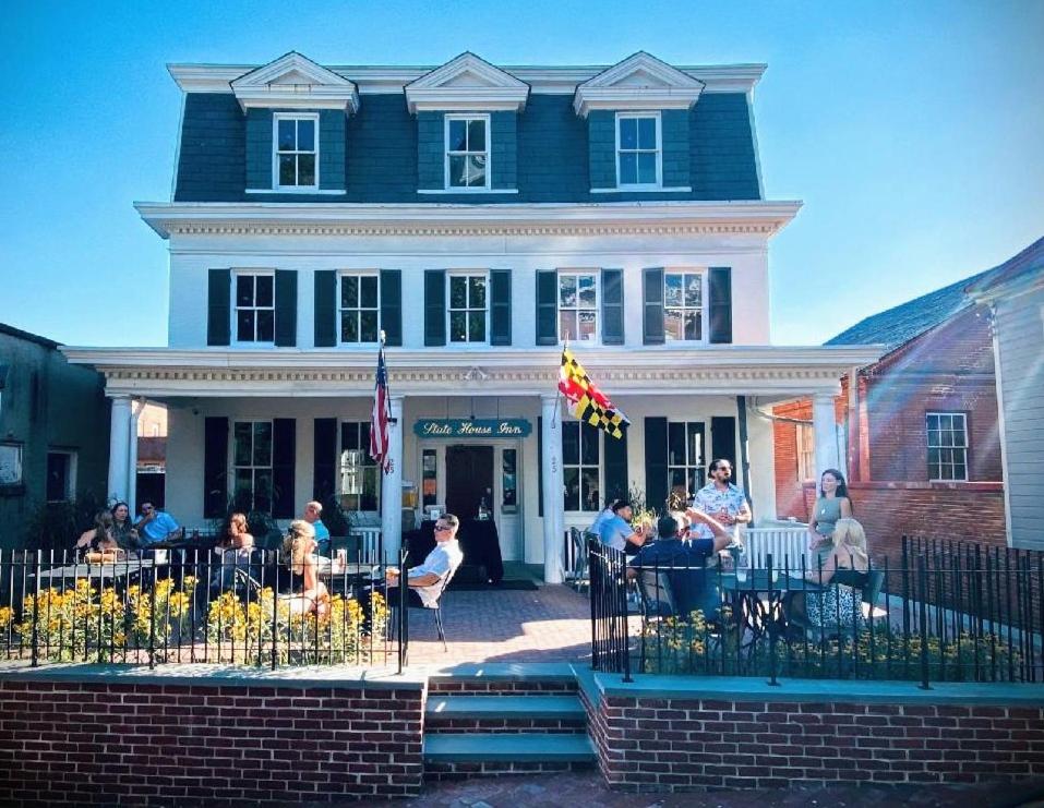 a group of people sitting at tables in front of a building at Capital Hotel Annapolis in Annapolis