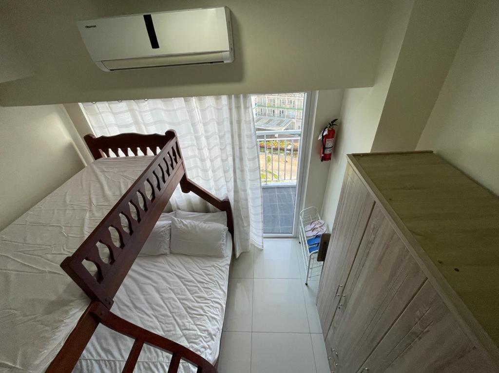 ein Schlafzimmer mit einem Etagenbett und einem Fenster in der Unterkunft A&B Condo with Netflix at SMDC Wind Residences in Tagaytay