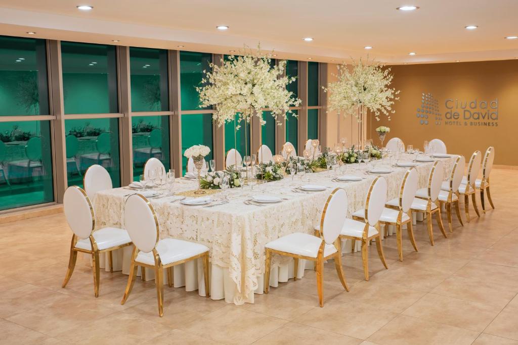 a long table in a room with white tables and chairs at Hotel Ciudad de David in David