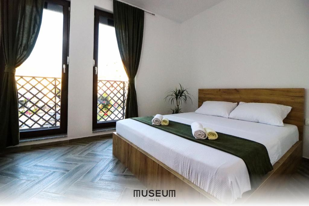 Museum Hotel في بريشتيني: غرفة نوم بسرير كبير عليها مناشف