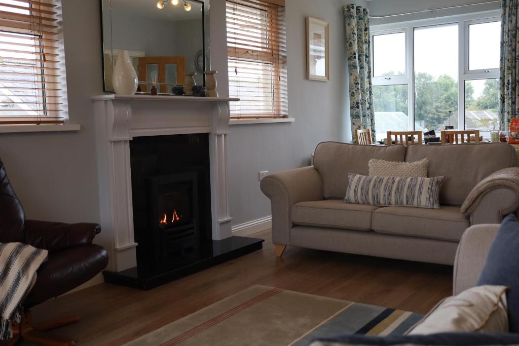 a living room with a couch and a fireplace at Benbradagh Country Cottage Causeway Coast in Dungiven