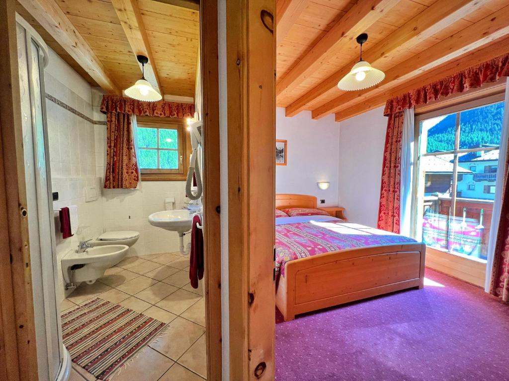sypialnia z łóżkiem i łazienką w obiekcie Bait da Jembro w Livigno
