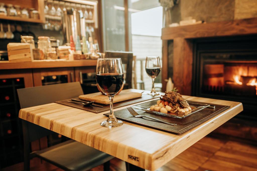 a table with two glasses of wine and a plate of food at NI-NEWEN Hotel & Lodge in Pucón