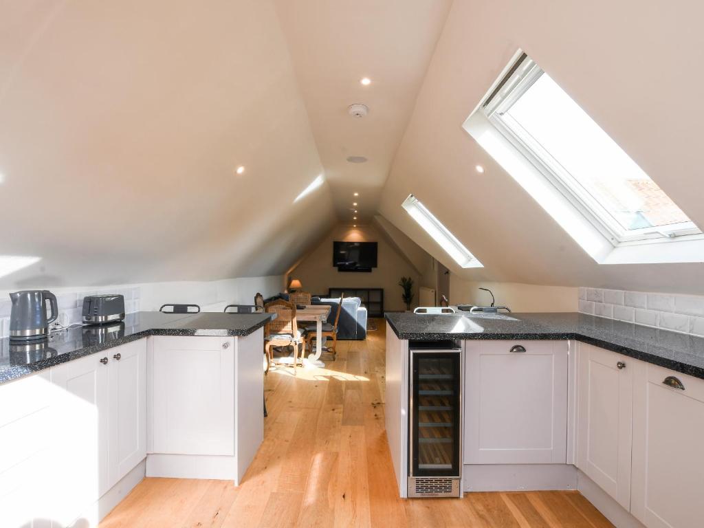 a kitchen with white cabinets and a skylight at The Cart Lodge in Ipswich