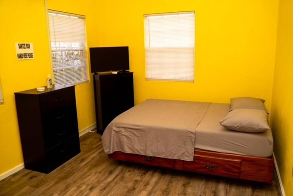 a bedroom with yellow walls and a bed and a dresser at Glasgow Villa at La Mar in Laborie