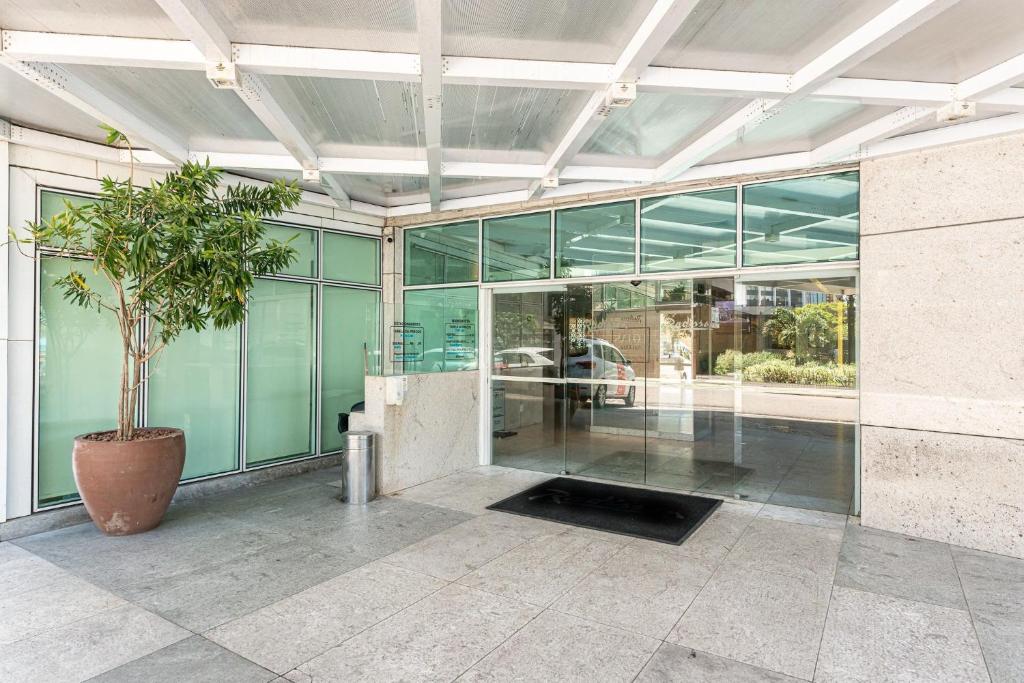 un grand bâtiment en verre avec un pot en face de lui dans l'établissement Apartamento em Hotel Beira Mar de Boa Viagem, à Récife