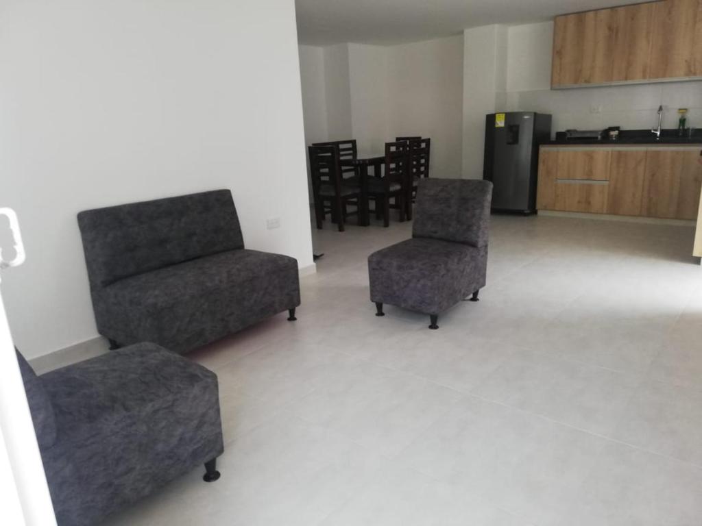 een woonkamer met 2 stoelen en een koelkast bij Hermoso apartamento nuevo primer piso in San Gil