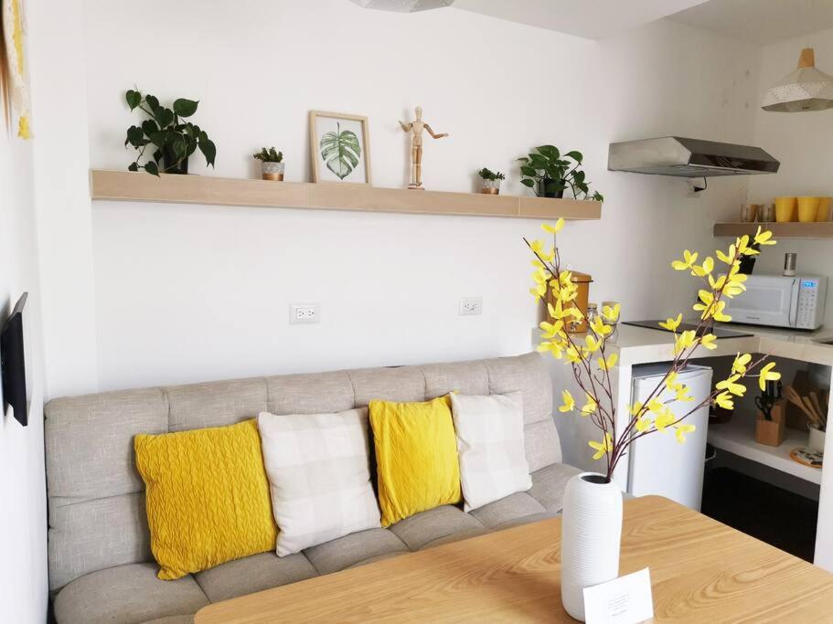 a living room with a gray couch with yellow pillows at Immaculate apartment G1 in Guatemala