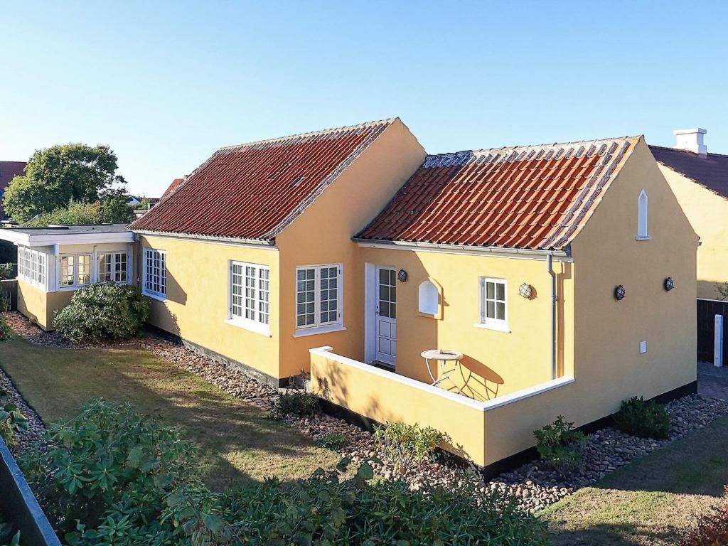 una casa amarilla con techo rojo en 6 person holiday home in Skagen-By Traum, en Skagen
