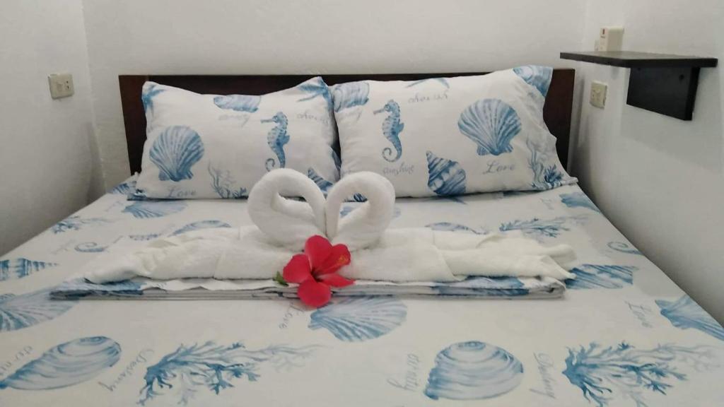 Dos cisnes hechos de toallas en una cama en JML Private 2-Double Room, en General Luna