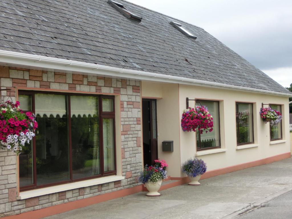 a building with flower pots on the side of it at Palmgrove Bed & Breakfast in Listowel