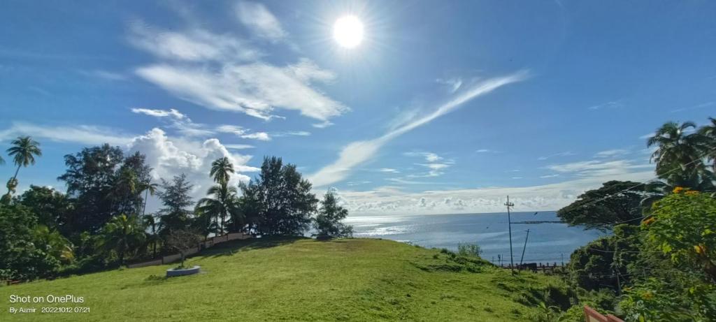 uma colina relvada com vista para o oceano em Andaman Castle em Port Blair