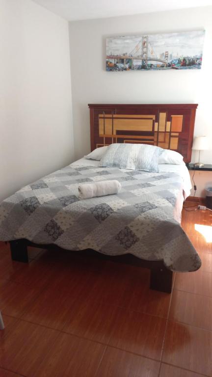 1 dormitorio con 1 cama con edredón en CASA LOPEZ, en Lima