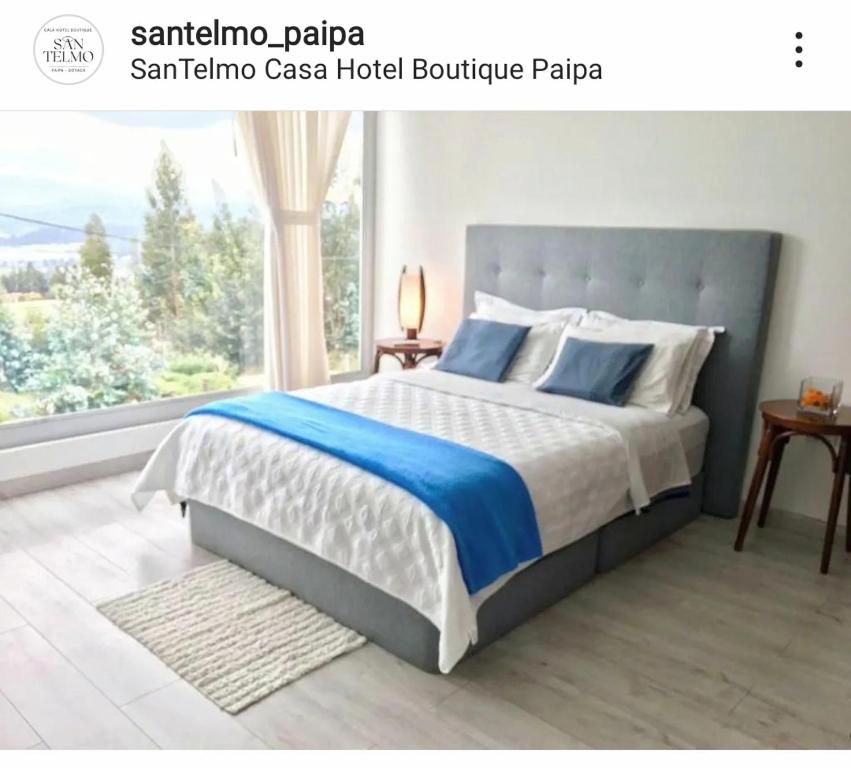 1 dormitorio con cama y ventana grande en Santelmo Casa Hotel Boutique, en Paipa