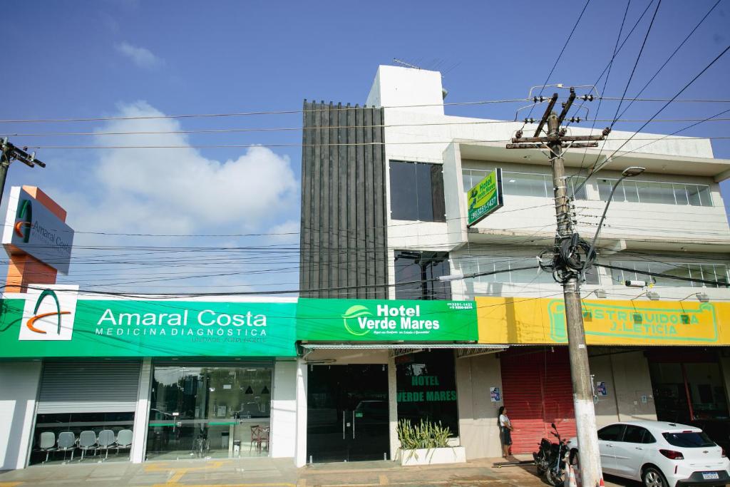 a store on a street corner with a building at Hotel Verde Mares in Macapá