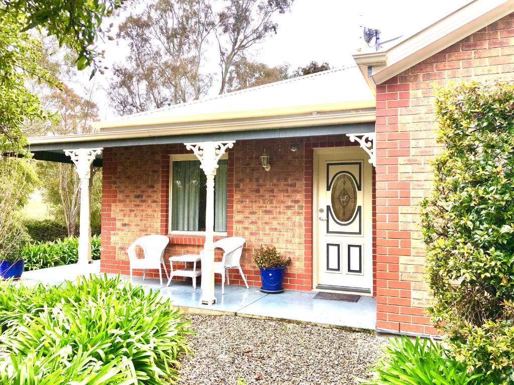a brick house with a table and chairs on a porch at Belle B&B Country Retreat in Penwortham