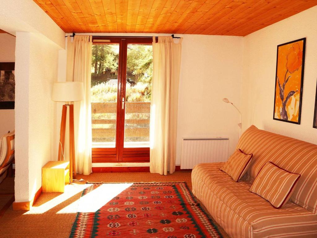 un salon avec un canapé et une grande fenêtre dans l'établissement Grand appartement 3 pièces, 9 pers, emplacement calme, animaux admis - FR-1-322-498, aux Orres