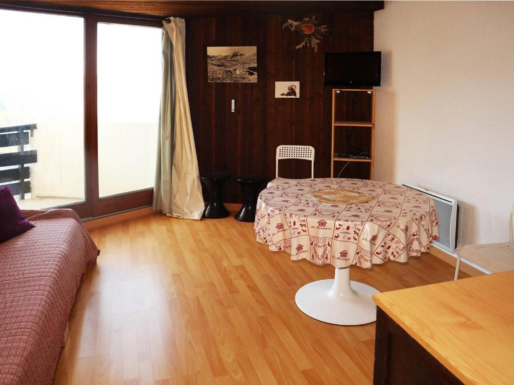 un salon avec une table et un canapé dans l'établissement Studio skis aux pieds pour 4, balcon - FR-1-322-497, aux Orres