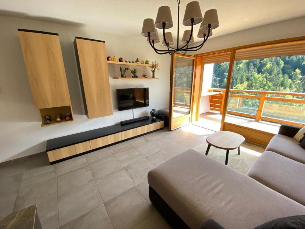 un salon avec un canapé et une table dans l'établissement Charmant appart 2 ch + coin nuit, balcon sud, garage, près de La Clusaz et commerces, St Jean de Sixt - FR-1-459-195, à Saint-Jean-de-Sixt
