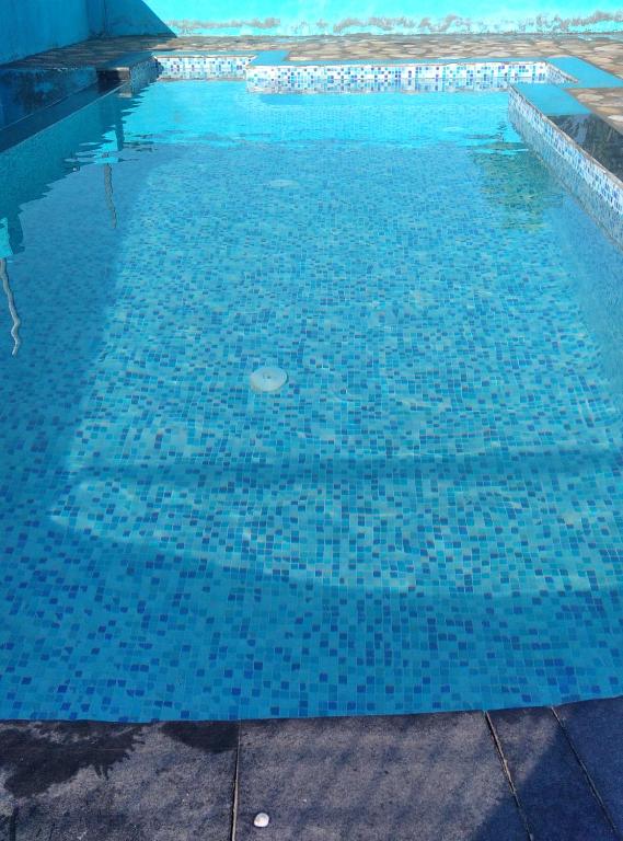 ein Pool mit blauen Fliesen auf dem Wasser in der Unterkunft Corbett Bhavesh home Stay in Jhirna