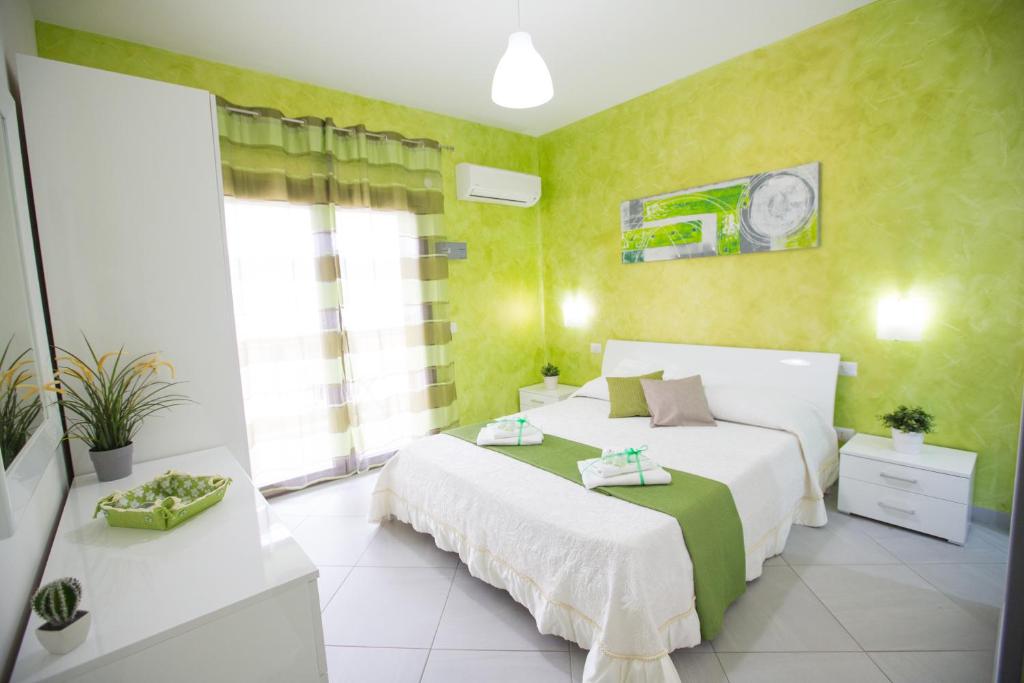 1 dormitorio con 2 camas y paredes amarillas en B&B Pepito, en Cefalú