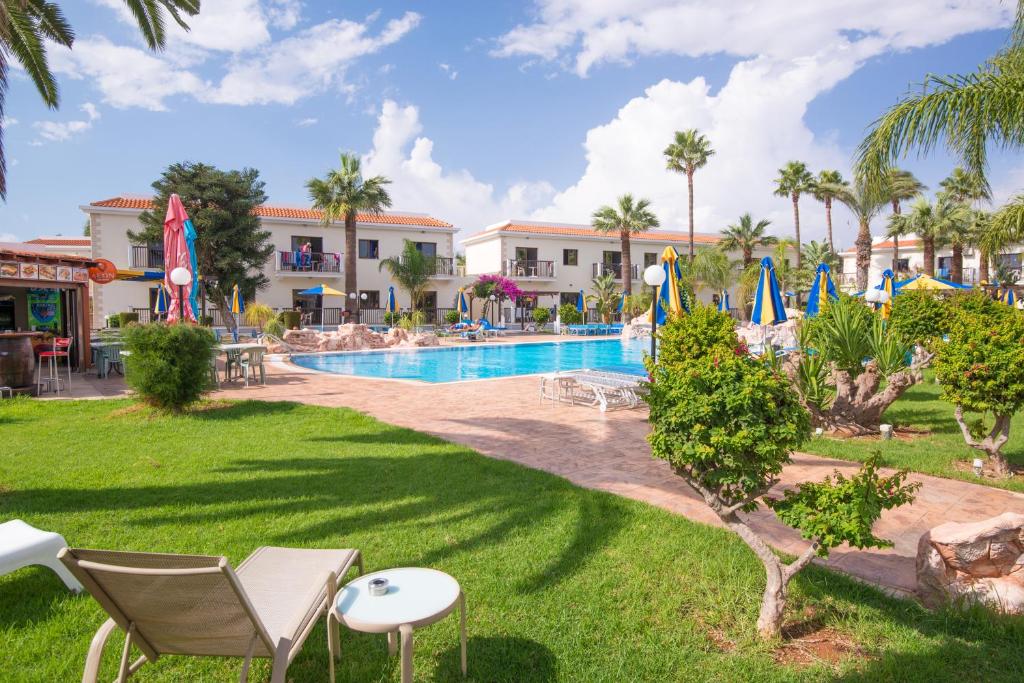 a resort with a swimming pool and palm trees at Loutsiana Deluxe Apts in Ayia Napa