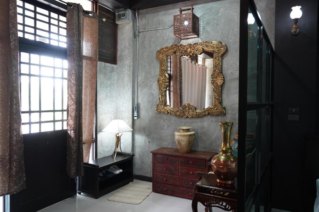 um quarto com um espelho e uma cómoda vermelha em Vathanagul Resort em Chiang Rai
