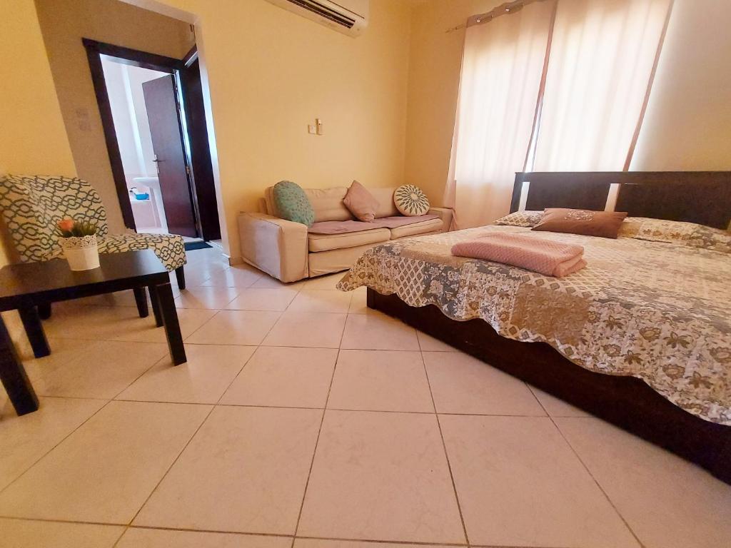 1 dormitorio con cama y sofá en DO ALL BY WALKING DISTANCE IN ALAIN, en Al Ain