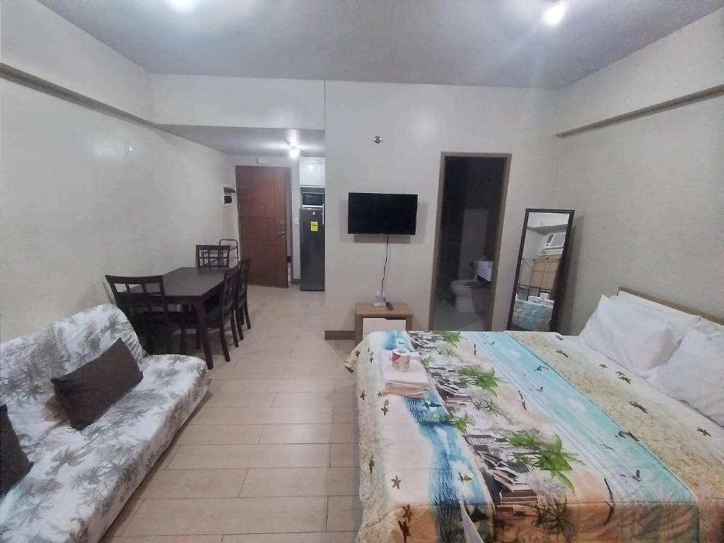 une chambre d'hôtel avec un lit et un canapé dans l'établissement RQUI CONDOTEL NEWPORT PASAY, à Manille