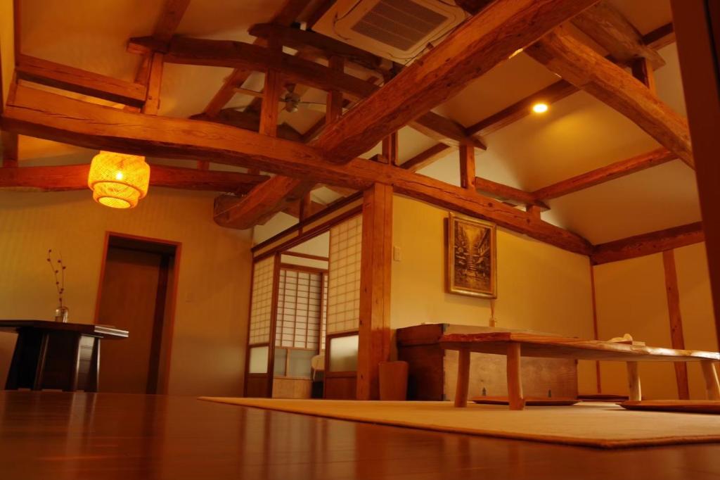 Cette chambre dispose d'une table et d'un plafond en bois. dans l'établissement 島宿糸, à Iki