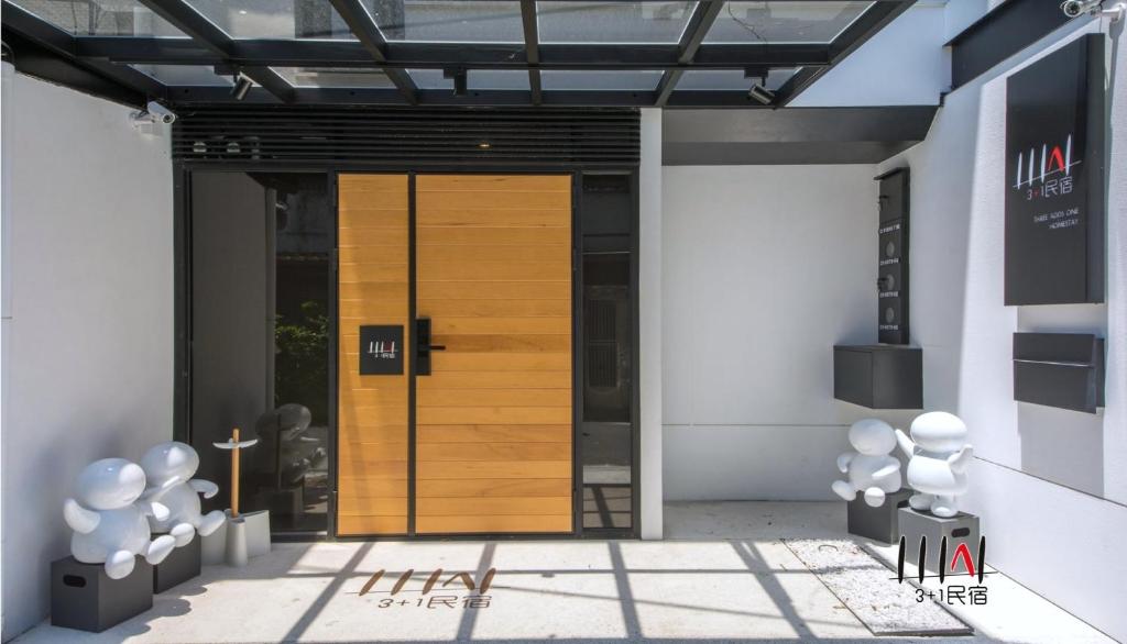 una puerta de madera en el lateral de un edificio en Three Adds One Homestay, en Luodong