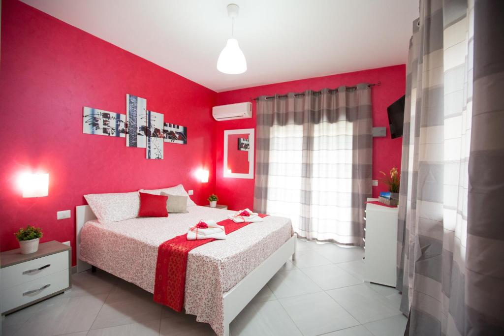 a red bedroom with a bed and a red wall at B&amp;B Pepito in Cefalù