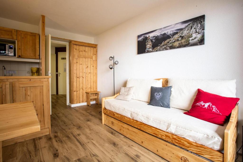 - un salon avec un canapé blanc et des oreillers rouges dans l'établissement Résidences quartier Charmettoger - maeva Home - Appartement 2 Pièces 5 Personnes - Sélection MAE-9614, à Arc 1800