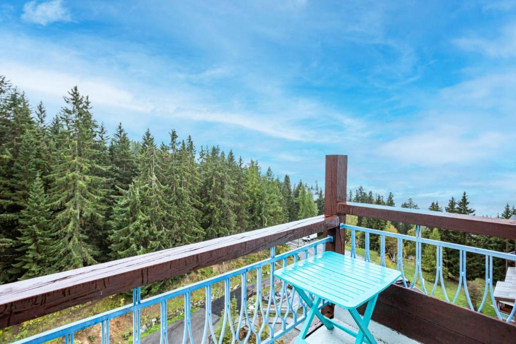 une table bleue sur un balcon avec vue sur les arbres dans l'établissement Résidences quartier Charmettoger - maeva Home - Studio 4 personnes - Sélection MAE-7494, à Arc 1800