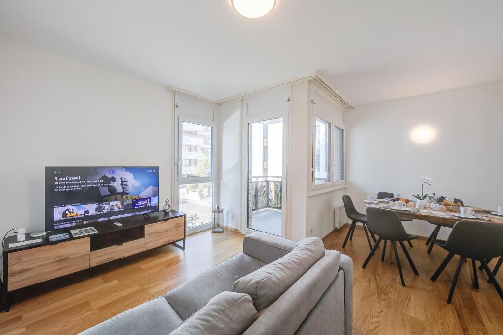 a living room with a couch and a tv and a table at Casa Al Molo - Happy Rentals in Locarno