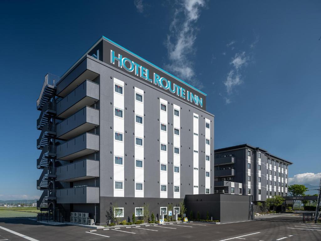 a hotel liquidity inn with a parking lot in front of it at Hotel Route-Inn Saku Minami Inter in Saku