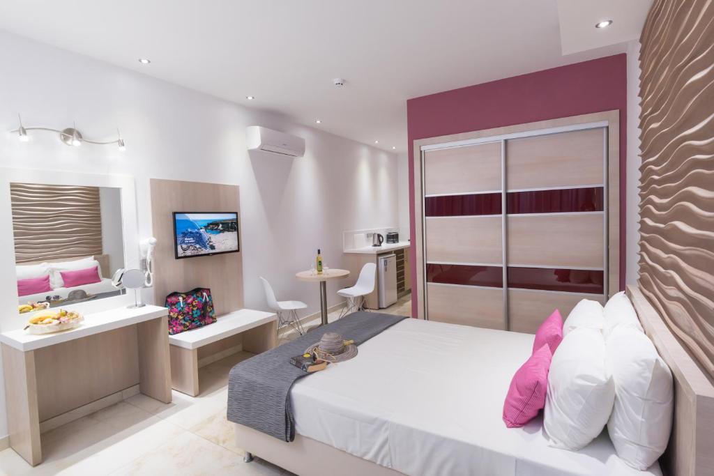 a hotel room with a bed and a bathroom at Loutsiana Deluxe Apts in Ayia Napa