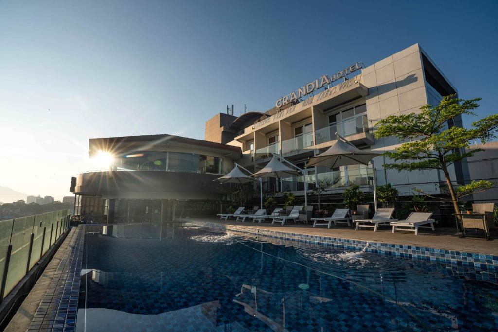 萬隆的住宿－格蘭蒂亞酒店，大楼前设有游泳池的酒店