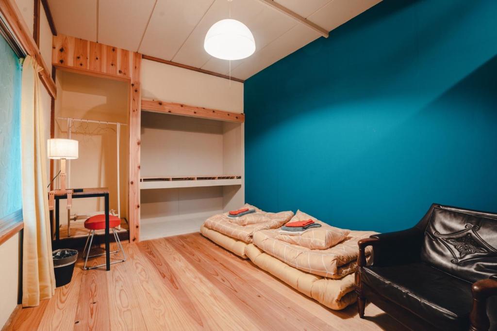 気仙沼市にあるSLOW HOUSE kesennuma - Vacation STAY 31901vの青い壁の客室で、ソファが備わります。