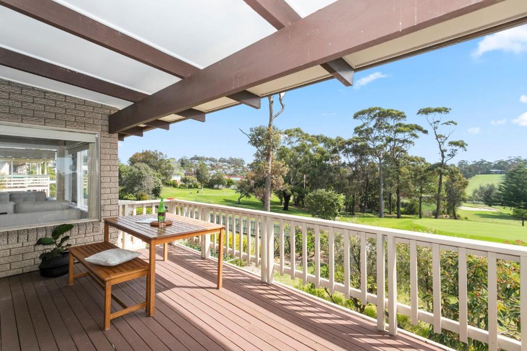 a wooden deck with a table and chair on it at Tee to Sea in Mollymook