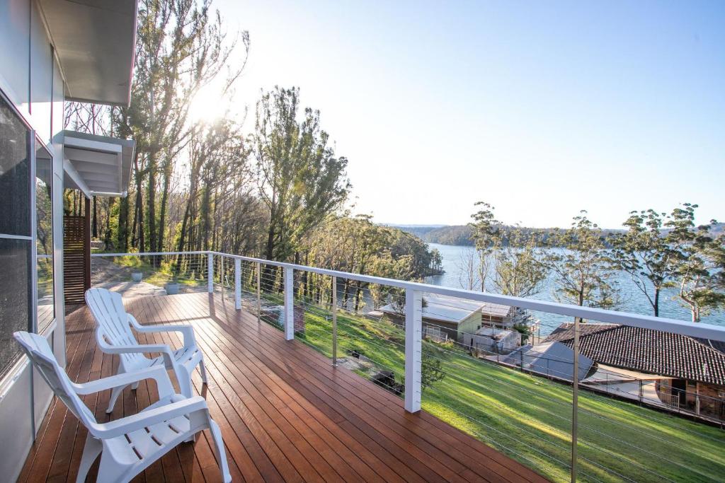 a balcony with two chairs and a view of the water at Home On the Water in Yatte Yattah