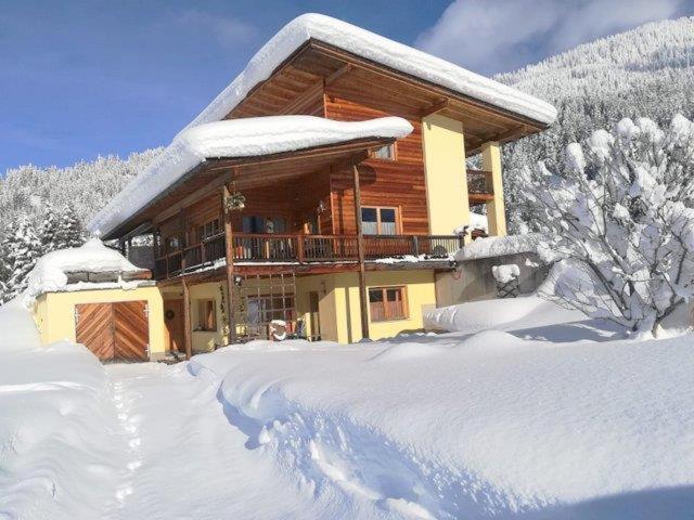 eine Blockhütte im Schnee mit schneebedeckten Bäumen in der Unterkunft Ferienwohnung Weitblick in Hochpillberg