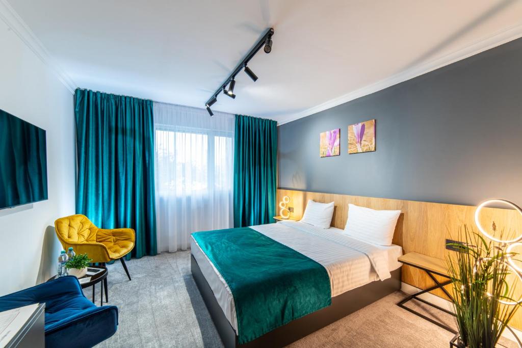 um quarto de hotel com uma cama e uma cadeira em Campeador Inn em Cluj-Napoca