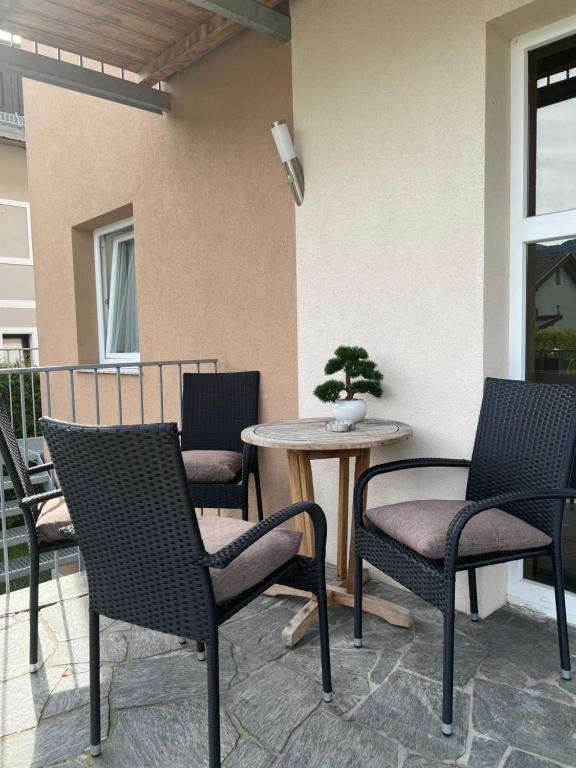 a patio with chairs and a table with a bonsai tree at Appartement Petra in Bruck an der Großglocknerstraße