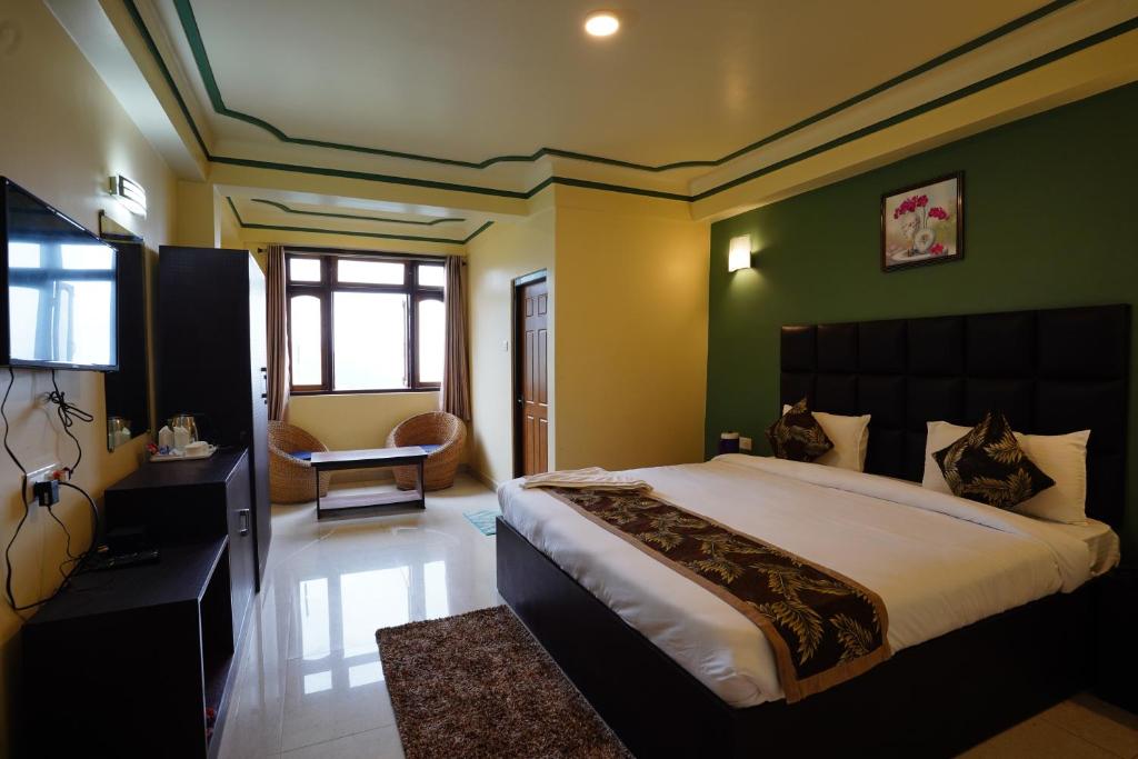 a bedroom with a large bed with green walls at Hotel White Lotus Gangtok in Gangtok
