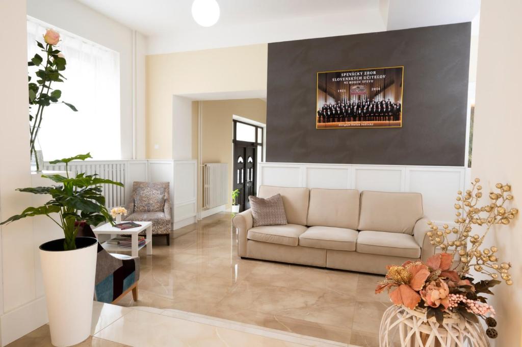 a living room with a couch and a wall with a picture at Hotel DSZSU in Martinske Hole