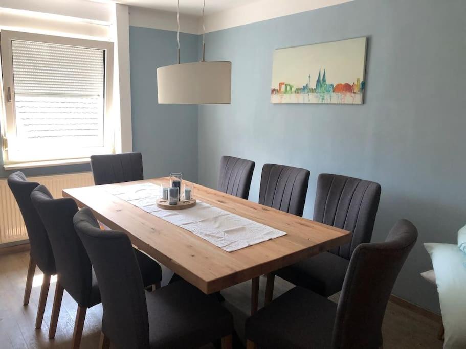 a dining room with a wooden table and chairs at Ferienwohnung Wolff am Natursteig Sieg und Westerwald in Pracht