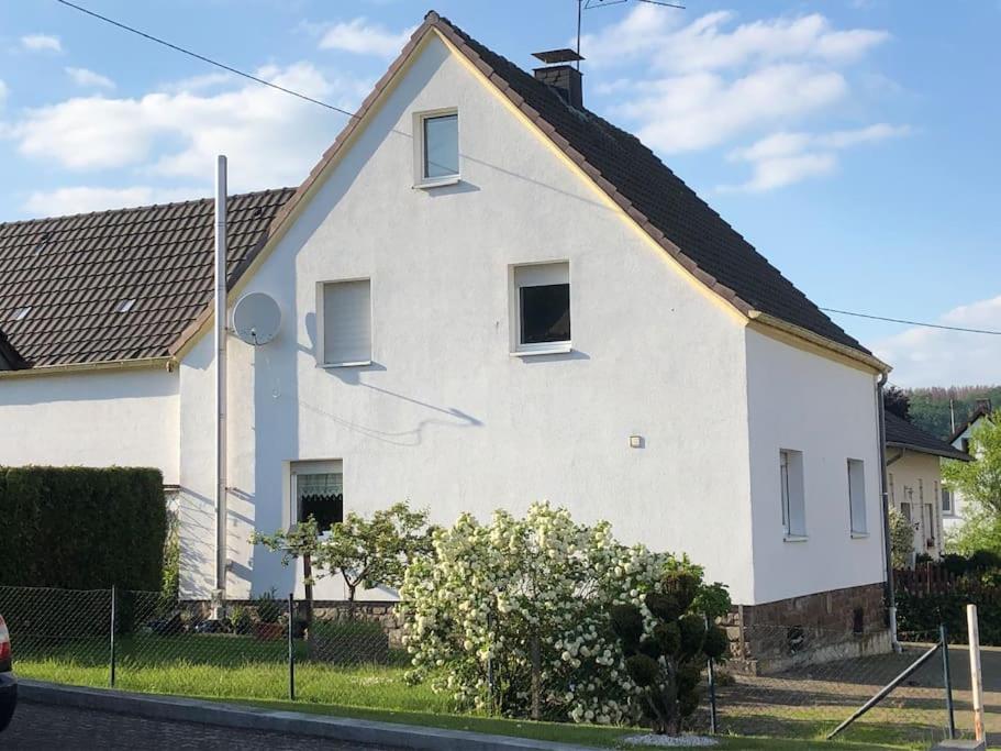 a white house with a black roof at Ferienwohnung Wolff am Natursteig Sieg und Westerwald in Pracht