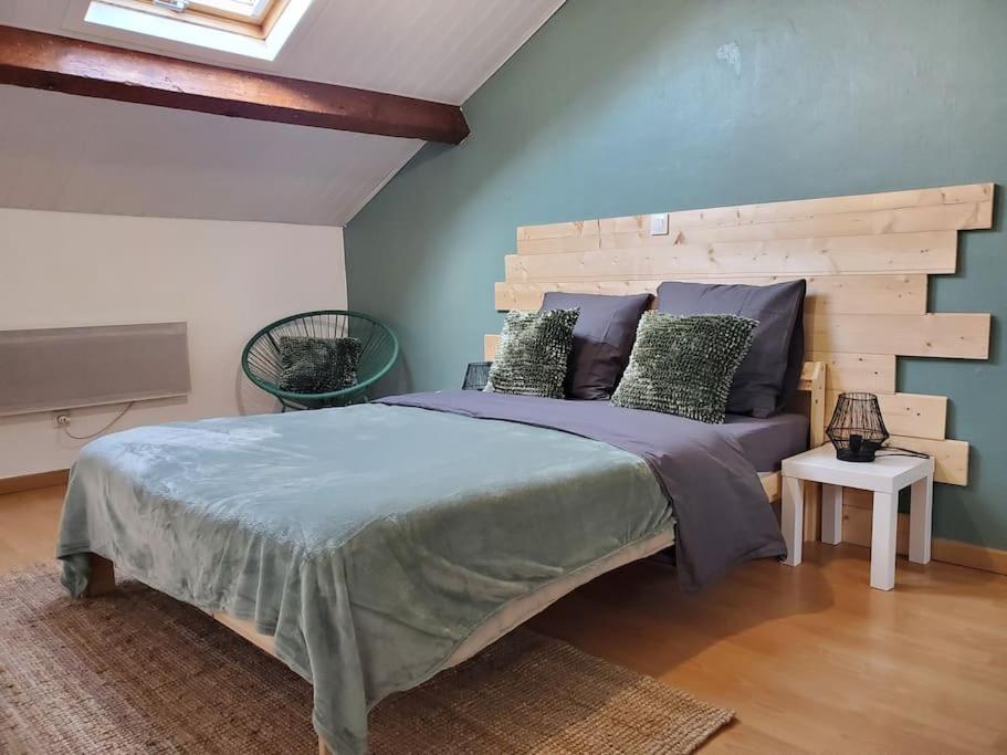 1 dormitorio con 1 cama grande y cabecero de madera en Sélénite, Chaleureuse et Cocooning. en Braux
